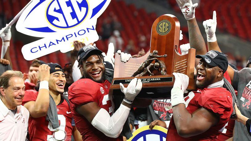Alabama coach Nick Saban and his players (from left, Bryce Young, Will Anderson and Phidarian Mathis) celebrate as they are presented the SEC Championship trophy after defeating Georgia on Dec. 4, 2021, in Atlanta. (Curtis Compton / Curtis.Compton@ajc.com)