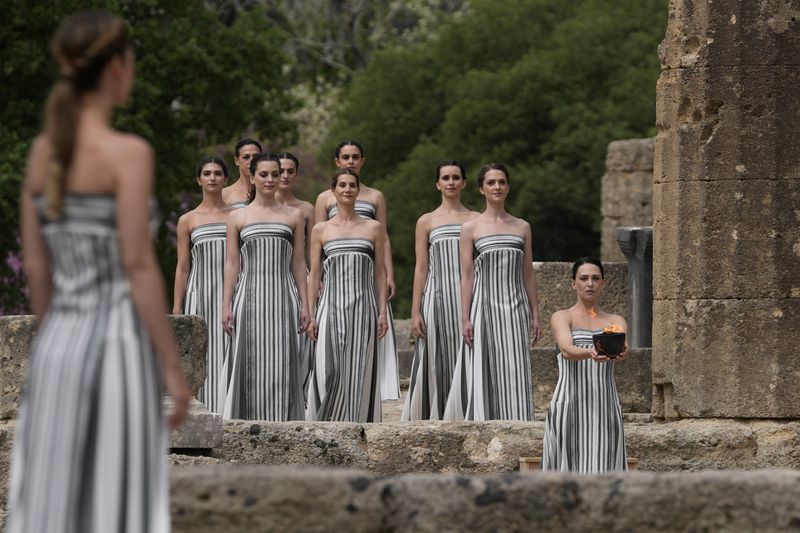 Performers take part in the official ceremony of the flame lighting for the Paris Olympics, at the Ancient Olympia site, Greece, Tuesday, April 16, 2024. The flame will be carried through Greece for 11 days before being handed over to Paris organizers on April 26. (AP Photo/Thanassis Stavrakis)