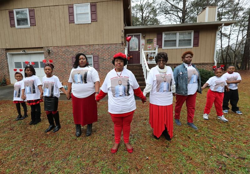 013121 Stone Mountain: Janet Morris (center), whose son Jireh Morris was killed in a December shooting at a DeKalb County apartment complex, and family members wearing justice for Jireh shirts join hands in front of the the family home on Sunday, Jan. 31, 2021, in Stone Mountain. From left are grandchildren Zoey Marie Starks, Skylar Michell Starks, Laia Cristina-Janet Starks, daughter Lana Marie Starks, Janet Morris, her mother Jeanette Ingersoll, daughter Brittany Michelle Morris, Jana Marie Evans, and Nolan Demond Evans.     Curtis Compton / Curtis.Compton@ajc.com”