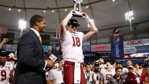 Quarterback Frank Nutile of the Temple Owls hoists his MVP trophy  following the Owls' 28-3 win over Fiu Golden Panthers at the Bad Boy Mowers Gasparilla Bowl on December 21, 2017 at Tropicana Field in St. Petersburg, Florida. Former Georgia Tech captain and ESPN sideline reporter Roddy Jones stands to his right. (Photo by Brian Blanco/Getty Images)