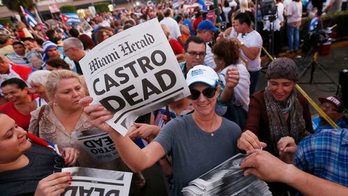 Alexandra Villoch, president and publisher of the Miami Herald Media Company, hands out a special edition of the Miami Herald with the headline "Castro Dead," in front of the Versailles Restaurant in the Little Havana neighborhood of Miami as members of the Cuban community react to the death of Fidel Castro, Saturday, Nov. 26, 2016. Castro, who led a rebel army to improbable victory in Cuba, embraced Soviet-style communism and defied the power of 10 U.S. presidents during his half century rule, died at age 90. (AP Photo/Wilfredo Lee)