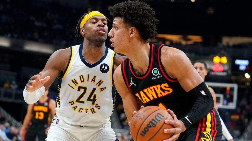 Jalen Johnson, right, looks to shoot against Indiana Pacers' Buddy Hield (24) during the first half of an NBA basketball game, Monday, March 28, 2022, in Indianapolis. (AP Photo/Darron Cummings)