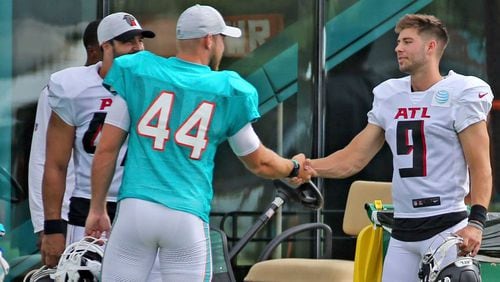 Dolphins long snapper Blake Ferguson (44) shakes hands with Falcons punter Dom Maggio (9) during a joint training camp practice at the Dolphins training facility Wednesday, Aug. 18, 2021, in Miami Gardens, Fla.  (Charles Trainor Jr./Miami Herald)