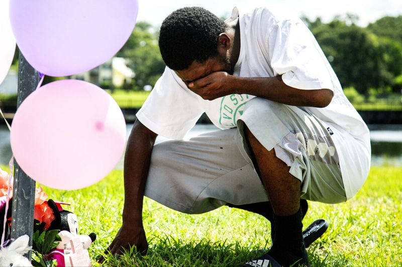 A relative of 4-year-old Je'Hyrah Daniels is overcome with emotion at a small memorial near where the girl was pulled from the Hillsborough River in Tampa on Thursday, Aug. 2, 2018. Je'Hyrah's mother, Shakayla Denson, 26, is accused of carrying the screaming girl into the river and dumping her in the murky water before wading out again. The girl's body was found by divers about 30 minutes later.