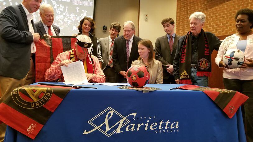Marietta Mayor Steve Tumlin signs the contract to sell 17 acres to Atlanta United following Thursday's called City Council meeting.
