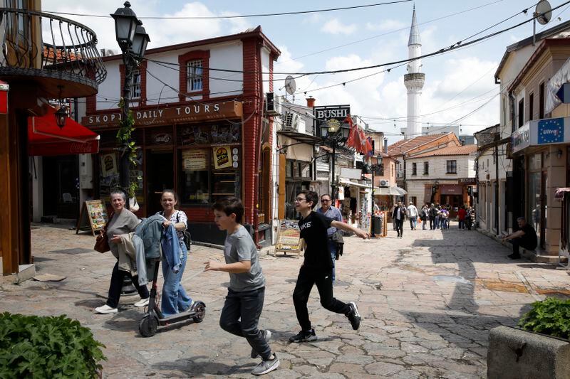 People pass through a street in the Old Bazaar, a day after the presidential and parliamentary elections, in Skopje, North Macedonia, on Thursday, May 9, 2024. North Macedonia elected its first woman president Wednesday as the governing Social Democrats suffered historic losses in twin presidential and parliamentary elections. (AP Photo/Boris Grdanoski)