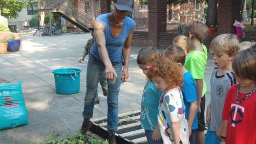Tania Herbert, who heads the Urban Agriculture program at the Paideia School, instructs elementary student on how to grow produce. Contributed.