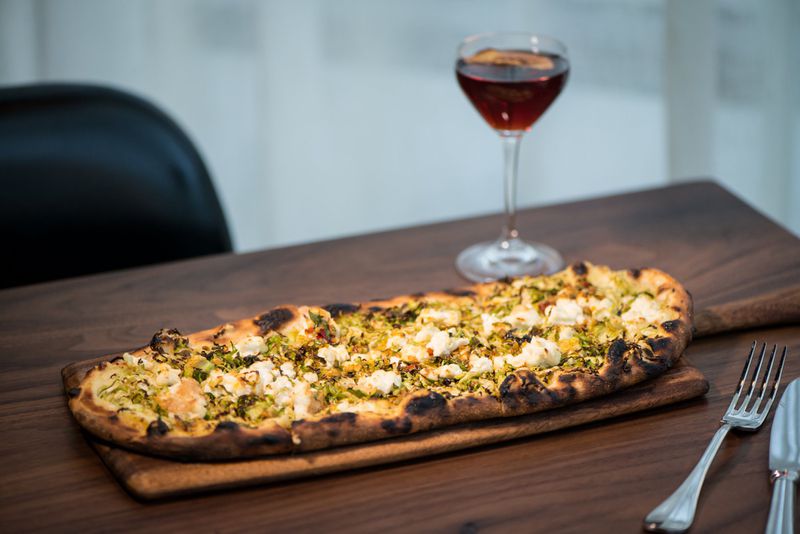 Brussels Sprouts, parsnip crema, and chile salsa verde Flatbread with Old Tom Cat cocktail. Photo credit- Mia Yakel.