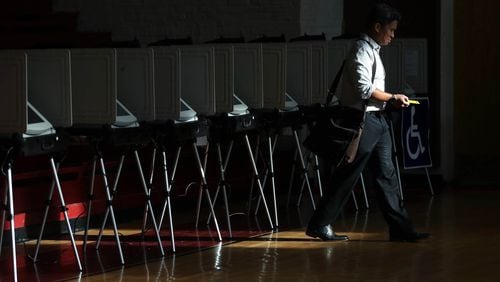 Sunlight streams through the windows of the gym as a voter walks away from the voting booths after voting during the Georgia runoff election voting at Henry W. Grady High School on July 24 in Atlanta. (JASON GETZ/SPECIAL TO THE AJC)
