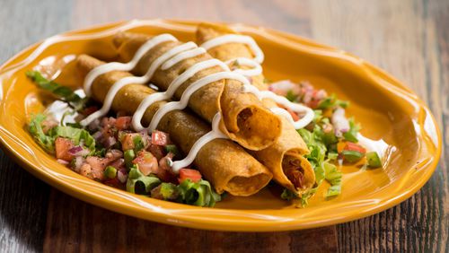 Chicken Flautas with shredded chicken, cotija cheese, onion and poblano in a corn tortilla, topped with lettuce, pico and cilantro with sour cream and queso. Photo credit- Mia Yakel.