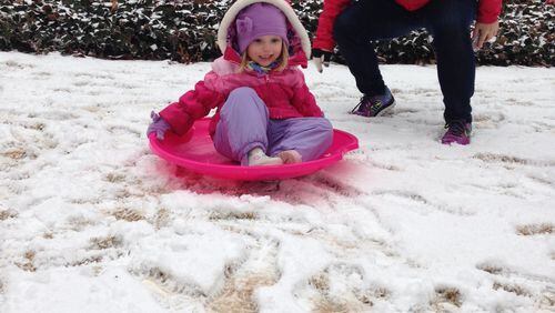East Cobb resident Reagan Goodnough and her daughter Hattie, 3, sled in their front yard. JAIME SARRIO / JSARRIO@AJC.COM