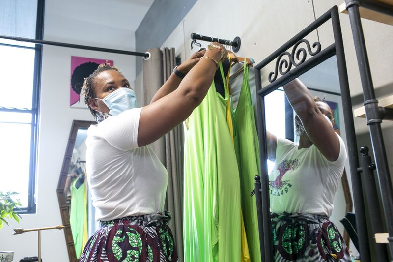 Frugal Chics Roc founder and creator Nyota Byfield adjusts a mannequin in her space in the Nia Building at Pittsburgh Yards. (Rebecca Wright for the Atlanta Journal-Constitution)