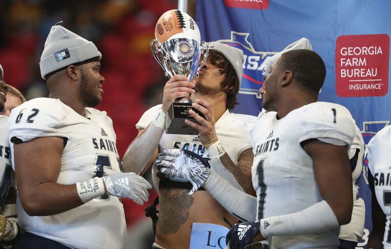 Cedar Grove wide receiver Jadon Haselwood, center, celebrates with the trophy after they defeated Peach County 14-13 in the Class AAA State Championship.
