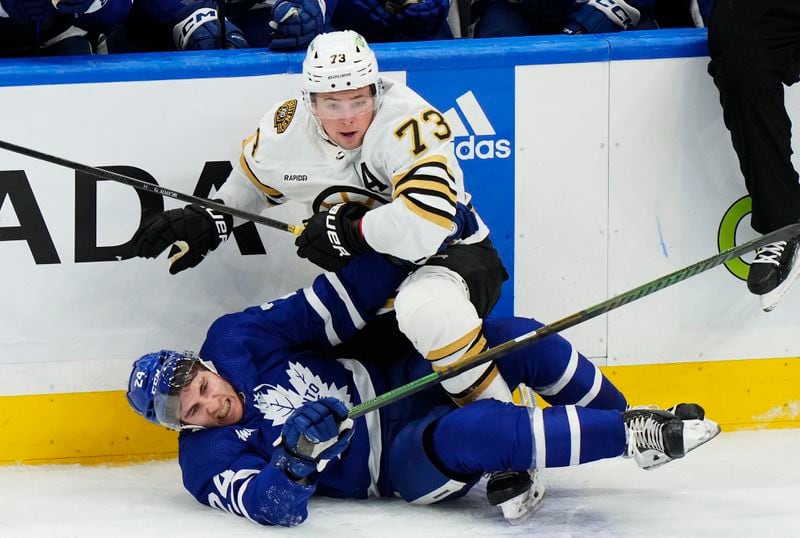 Boston Bruins' Charlie McAvoy (73) checks Toronto Maple Leafs' Connor Dewar (24) during the second period of action in Game 3 of an NHL hockey Stanley Cup first-round playoff series in Toronto on Wednesday, April 24, 2024. (Frank Gunn/The Canadian Press via AP)