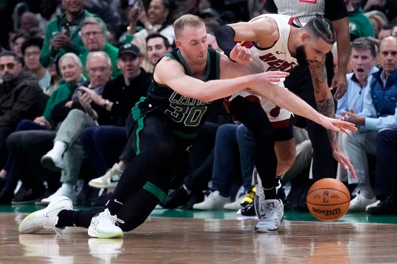 Boston Celtics forward Sam Hauser (30) battles Miami Heat forward Caleb Martin for the ball during the first half of Game 5 of an NBA basketball first-round playoff series, Wednesday, May 1, 2024, in Boston. (AP Photo/Charles Krupa)