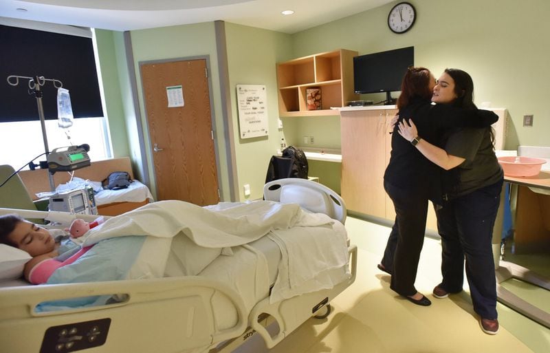 Caitlin Pirello (right) gets a hug from the mother of the patient Meital Ginzberg as Noa Ginzberg, 7, who undewent surgery because of broken arm at Children’s Healthcare of Atlanta’s Scottish Rite Hospital in Sandy Spring. HYOSUB SHIN / HSHIN@AJC.COM