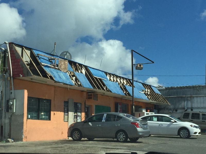 Three months after Hurricanes Irma and Maria damaged St. Thomas, many business and home rooftops remained covered with tarps as residents await federal loan assistance to make repairs. NICOLE CARR / WSB-TV