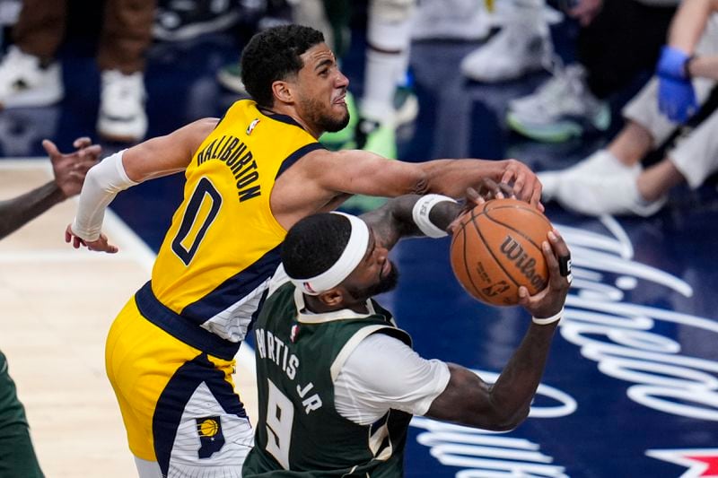 Milwaukee Bucks forward Bobby Portis (9) grabs a rebound behind Indiana Pacers guard Tyrese Haliburton (0) during the second half in Game 2 in an NBA basketball first-round playoff series, Friday, April 26, 2024, in Indianapolis. (AP Photo/Michael Conroy)
