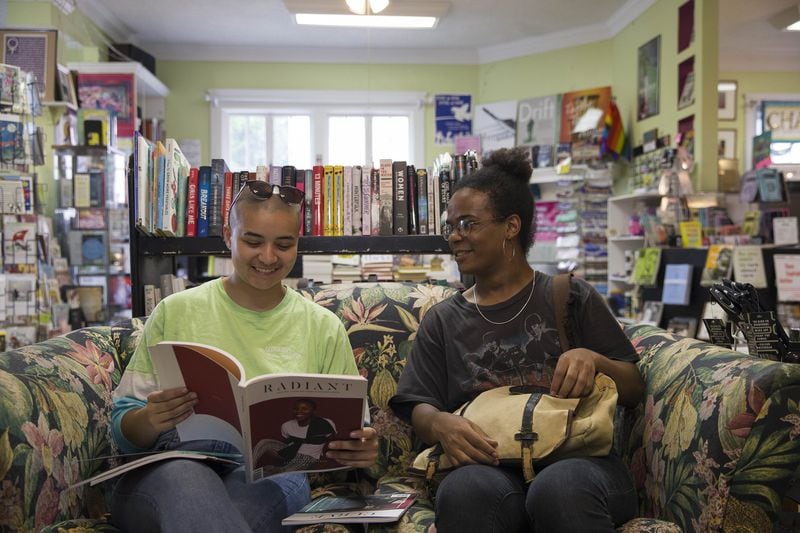 Anna Muñoz (left) and Ariane McCullough (right) browse through a magazine at Charis Books and More in Atlanta’s Little Five Points community. (ALYSSA POINTER/ALYSSA.POINTER@AJC.COM)