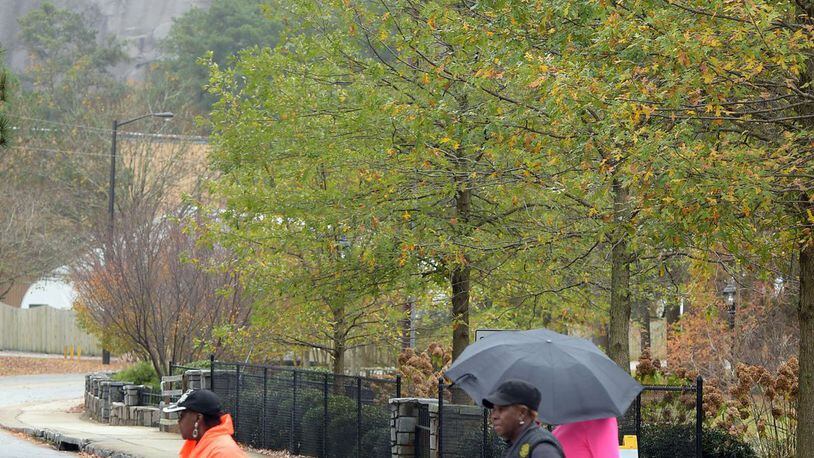 People exercise under gray skies Thursday at Stone Mountain Park. A large proportion of the park’s visitors are African-American, despite the park’s Confederate themes. KENT D. JOHNSON/KDJOHNSON@AJC.COM