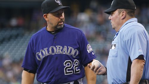 Colorado Rockies manager Walt Weiss, left, confers with home plate umpire Marty Foster after Rockies left fielder Ryan Raburn bobbled and then dropped a fly ball hit by Atlanta Braves' Freddie Freeman that was ruled a triple in the first inning of a baseball game Friday, July 22, 2016, in Denver. (AP Photo/David Zalubowski)
