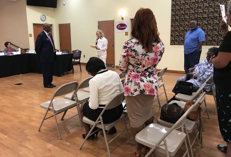 State Sen. Emanuel Jones, D-Lithonia (standing at left), listens to public comment from Mary Hinkel (center, in white) during the DeKalb County Delegation’s town hall meeting on Sept. 16, 2019. Other members of the audience stand in support of Hinkel, who opposes the ethics referendum. (TIA MITCHELL/TIA.MITCHELL@AJC.COM)