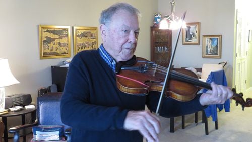 Dr. Tom McDermott, 89, practices the violin at his home in St. George Village, a retirement community in Roswell.