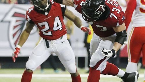 Atlanta Falcons tackle Ryan Schraeder (73) spikes the ball as Atlanta Falcons running back Devonta Freeman (24) looks on after Freeman scored a touchdown against the Kansas City Chiefs during the second half of an NFL football game, Sunday, Dec. 4, 2016, in Atlanta. (AP Photo/John Bazemore)