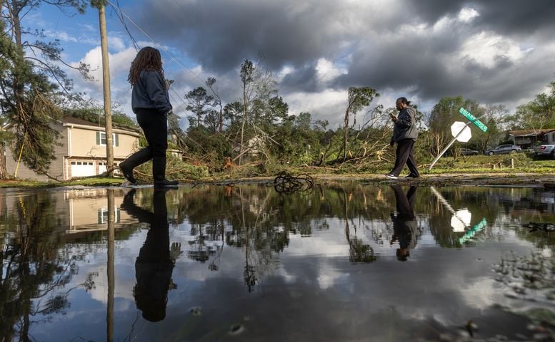 Where Briarwood Road and Briarwood Drive meet, Dianne Carter (left)  and Brenda Gales (right) are reflected against the widespread damage after storms hit the area on the night of  Tuesday, April 2, 2024 in Rockdale County. (John Spink / John.Spink@ajc.com)