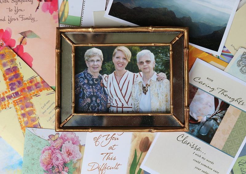 An October 2019 family photo of (from left) Clarissa Strickland, her daughter Courtenay Strickland, and her sister Nan Durrett is seen with sympathy cards. Nan Durrett, 74, died last month after becoming ill in an assisted living home. Her family believes the state needs to set higher care standards for the senior care industry. (Curtis Compton /ccompton@ajc.com)