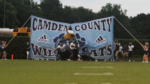 The Camden County High School football team runs through a banner prior to its Sept. 4 game against Glynn Academy. (Credit: camdencountywildcatfootball.com)