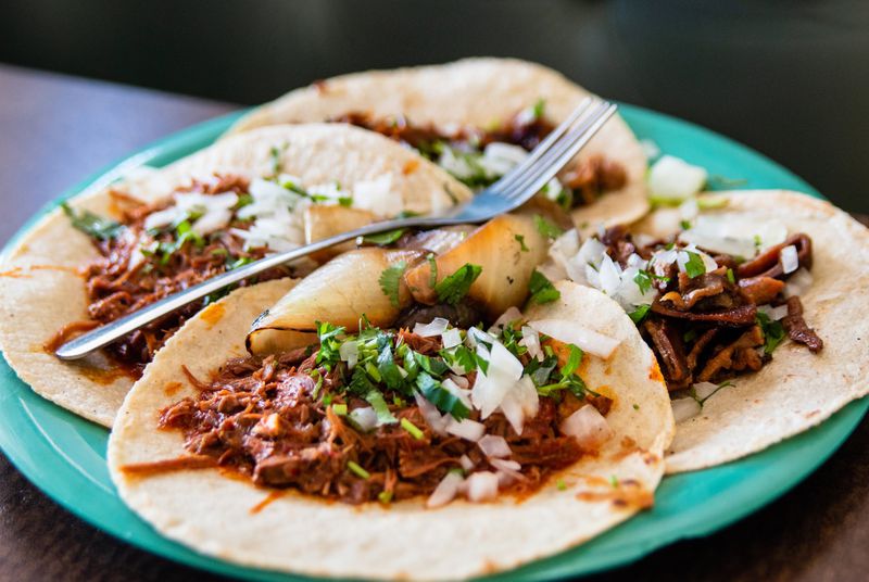 A plate of four tacos from El Rey Del Taco, including goat barbacoa (foreground) and buche, or pig stomach (background). CONTRIBUTED BY HENRI HOLLIS