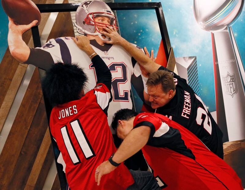 Falcons fans show their feelings about Tom Brady at a cardboard cutout of the QB at the NFL Experience in 2017.   BOB ANDRES  /BANDRES@AJC.COM