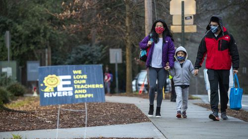 In this file photo, parents and guardians escort their E. Rivers Elementary School students to the building for in-person learning at Atlanta’s Peachtree Battle Alliance community. Many students have returned to school in recent weeks. (Alyssa Pointer / Alyssa.Pointer@ajc.com)
