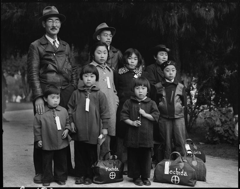 A Japanese family waits to be taken to an internment site. During the first months after Pearl Harbor 117,000 Japanese Americans were told to sell their property and they were moved to camps that often featured primtive accommodations. CONTRIBUTED: ABBY GINZBERG/DOROTHEA LANGE