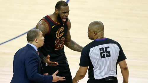 LeBron James and his head coach Tyronn Lue discuss a few of Game One's finer points with ref Tony Brothers Thursday.  (Lachlan Cunningham/Getty Images)
