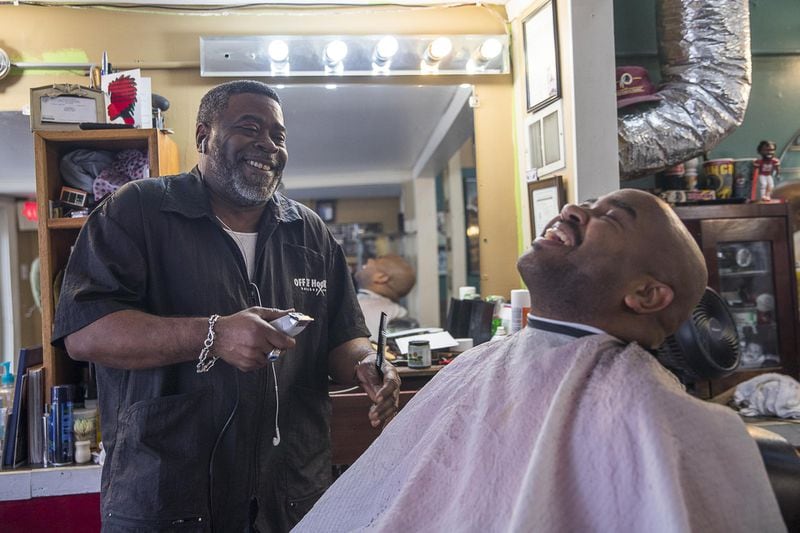 01/18/2019 — Atlanta, Georgia — Barber and owner of Off The Hook Barber Shop Karl Booker (left) shares a laugh with his customer, Keino Robinson, as they discuss football at the shop in Atlanta’s Castleberry Hill community, Friday, January 18, 2019. Booker, a Dallas Cowboys fan, believes that if the New Orleans Saints make it to Super Bowl LIII, Atlanta’s economy, for all areas of the city, will be impacted positively. (ALYSSA POINTER/ALYSSA.POINTER@AJC.COM)