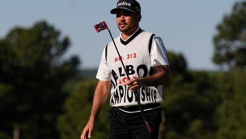 Jason Day, of Australia, waves after making a putt on the 18th hole during the weather delayed first round round at the Masters golf tournament at Augusta National Golf Club Friday, April 12, 2024, in Augusta, Ga. (AP Photo/George Walker IV)