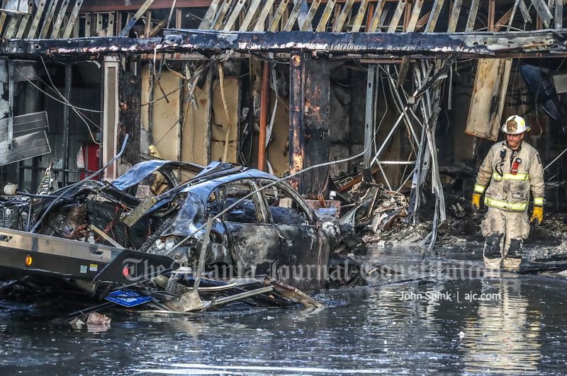 The fire caused structural damage at the business strip, which needed to be addressed before crews could remove the charred Porsche Cayenne from the wreckage.