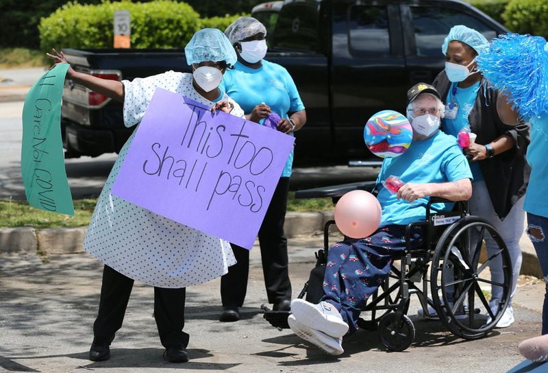 Dietary supervisor Yolanda Fears (left) celebrates during a family and community parade held in May for residents and staff who have survived COVID-19 at Westbury Medical Care & Rehab. CURTIS COMPTON / CCOMPTON@AJC.COM