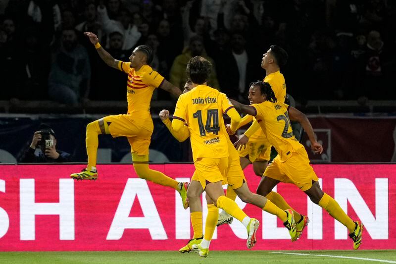 Barcelona's Raphinha, left, celebrates after scoring his side's second goal during the Champions League quarterfinal first leg soccer match between Paris Saint-Germain and Barcelona at the Parc des Princes stadium in Paris, Wednesday, April 10, 2024. (AP Photo/Lewis Joly)