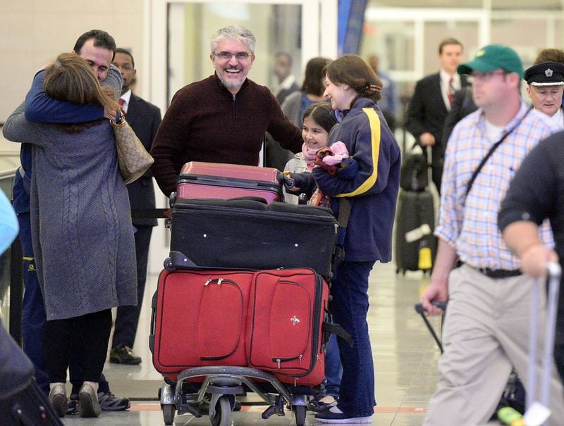 JANUARY 28, 2017 ATLANTA Mansour Kenereh (center in purple sweater) reunites with family members in the International arrivals lobby at Hartsfield Jackson International Airport Saturday January 25, 2017.The family of 3 were among several people detained at the Customs and Border Protection office following an executive order from President Trump limiting immigration. Kent D. Johnson/AJC *** FAMILY MEMBERS DECLINED TO BE IDENTIFIED***
