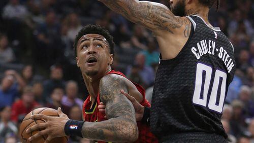 The Hawks' John Collins (left) tries to find a path against Kings center Willie Cauley-Stein. (AP Photo/Rich Pedroncelli)