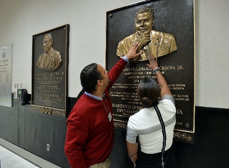 In 2014, Maynard H. Jackson III, left, and Candace Byrd, then Chief of Staff for Atlanta Mayor Kasim Reed, touch a newly unveiled bronze relief plaque of Jackson’s father, Maynard Jackson, created by local artist Fred Ajanogha. (Brant Sanderlin/AJC 2014 photo)