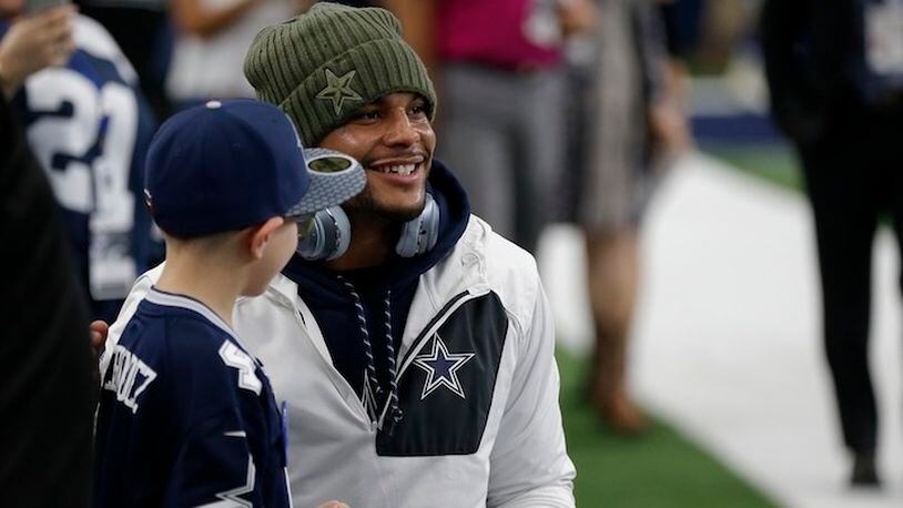 Dallas Cowboys' Dak Prescott poses for a photo with a young fan before an NFL football game against the Kansas City Chiefs on Sunday, Nov. 5, 2017, in Arlington, Texas. (AP Photo/Brandon Wade)
