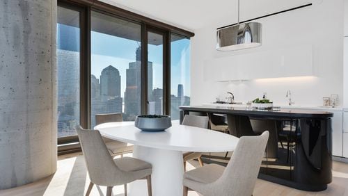 An oval-shaped dining table helps anchor this modern dining space. (Design Recipes)