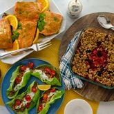 Mediterranean Lentil Walnut Lettuce Cups (clockwise, from bottom left), Baked Orange Mustard Salmon with Asparagus, and Reduced Sugar Berry Crisp make a colorful table and can help optimize brain health. (Virginia Willis for The Atlanta Journal-Constitution)