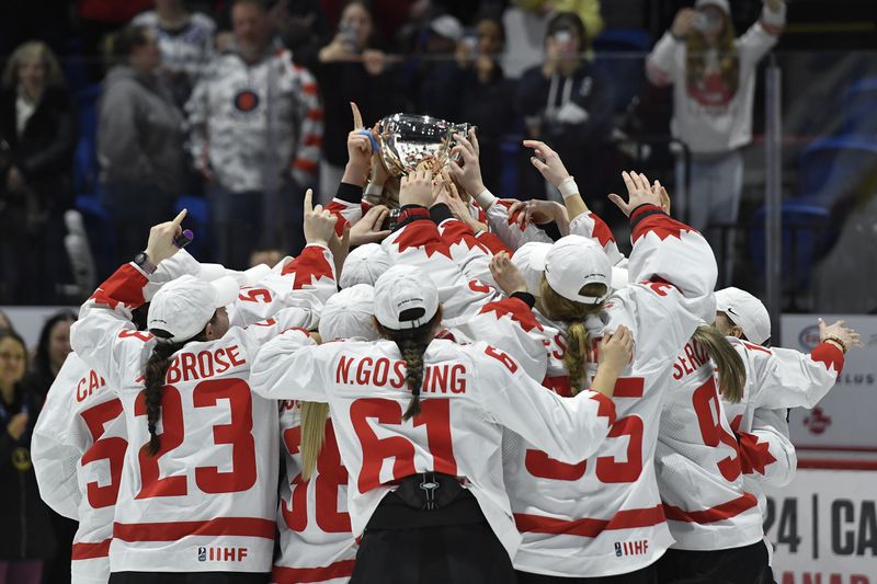 Team Canada raises the championship cup after beating the United States in the final at the women's world hockey championships in Utica, N.Y., Sunday, April 14, 2024. (AP Photo/Adrian Kraus)