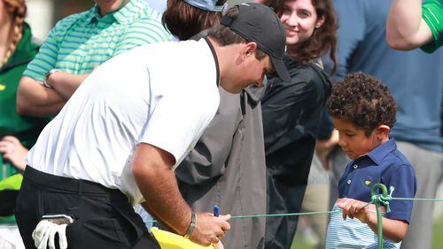 Defending Masters champion Patrick Reed pauses to sign an autograph for a young fan during the Drive, Chip, and Putt Championship at Augusta National Golf Club on Sunday, April 7, 2019, in Augusta.    Curtis Compton/ccompton@ajc.com