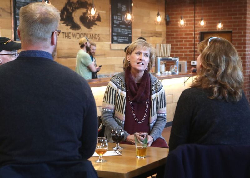 Furloughed workers Nathan Jordan (from left), Daria Labinsky and Maureen Hill, all with the National Archives, discuss the partial federal shutdown while relaxing at SweetWater Brewing Company during an event offering free food and beer to furloughed federal workers on Thursday, Jan. 10, 2019, in Atlanta. 